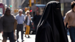 muslim-woman-wearing-a-black-niqab-in-front-of-a-crowd-of-people