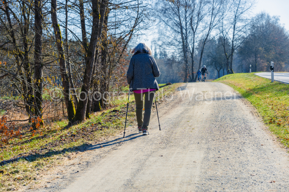 Nordic walking - woman with Nordic walking poles on a country road