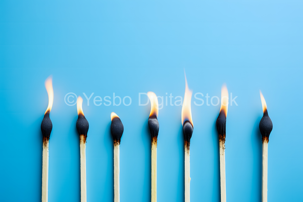 Burning match on a blue background. Conceptual image of fire.